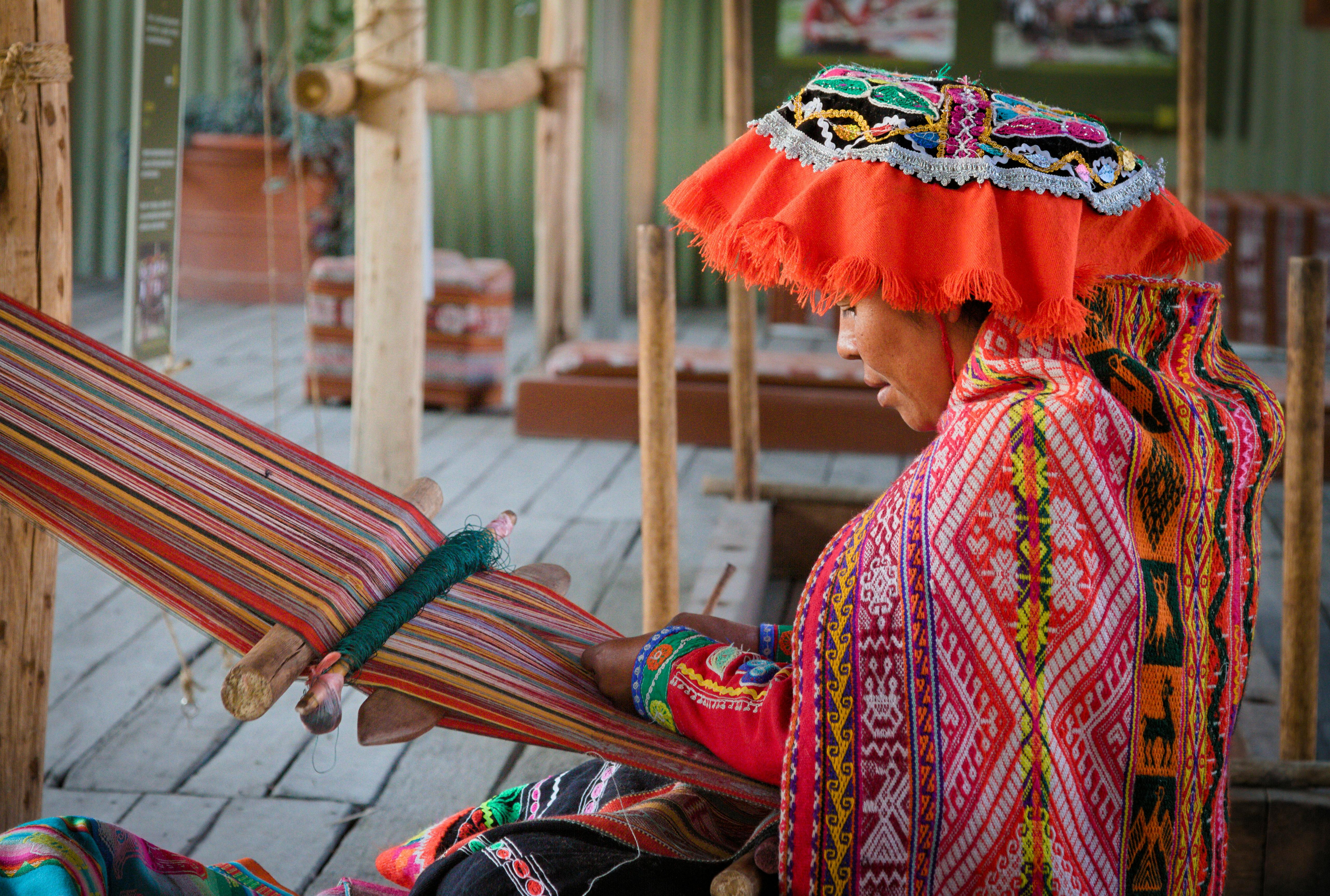 Traditional artisan weaving colorful textiles in authentic cultural dress